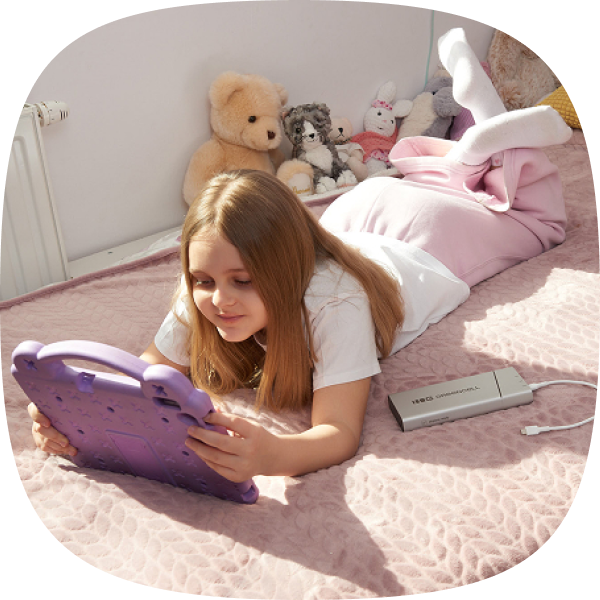 A photo of a child using a tablet with PowerPlay Pro next to it