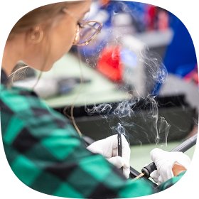 A photo of a woman soldering electronic components