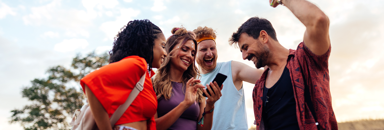 Nuotrauka grupės žmonių žiūrint į telefoną