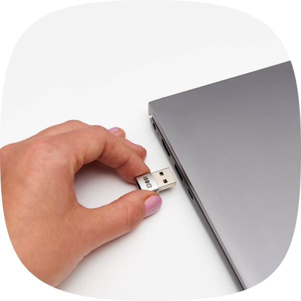 Zdjęcie przedstawia dłoń podłączającą adapter GCAC1 do portu USB-A w laptopie